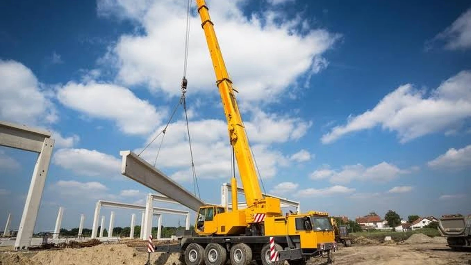 Mobile crane lifting a beam on an infrastructure project in India.